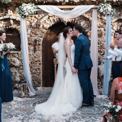 bride & groom kiss at rustic wedding ceremony in Crete