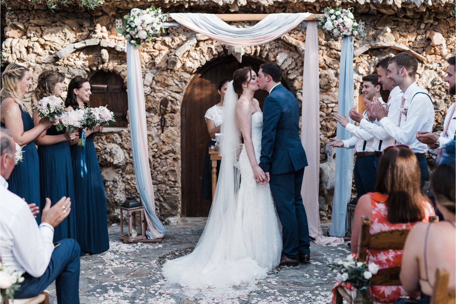 bride & groom kiss at rustic wedding ceremony in Crete